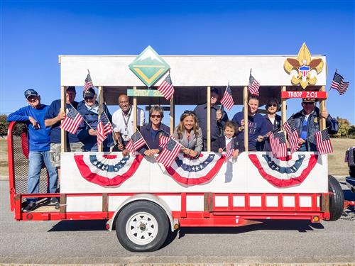 decorated float adorned in red white and blue bunting with veterans waving from windows